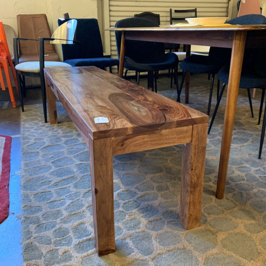 Wooden bench in a room with chairs and tables