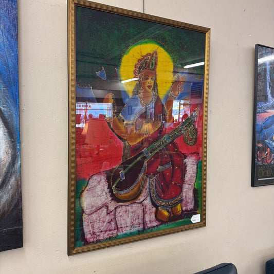 Framed artwork of a person playing a stringed instrument on a wall.