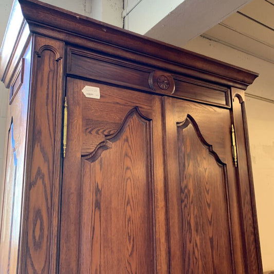 Wooden wardrobe with decorative carvings on a plain background