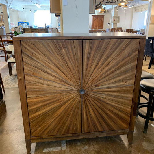 Wooden cabinet with sunburst design in a showroom setting