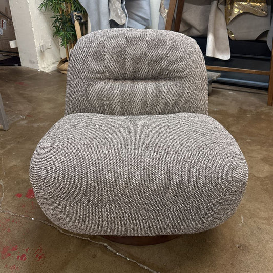 Gray textured armchair on a concrete floor with a blurred background