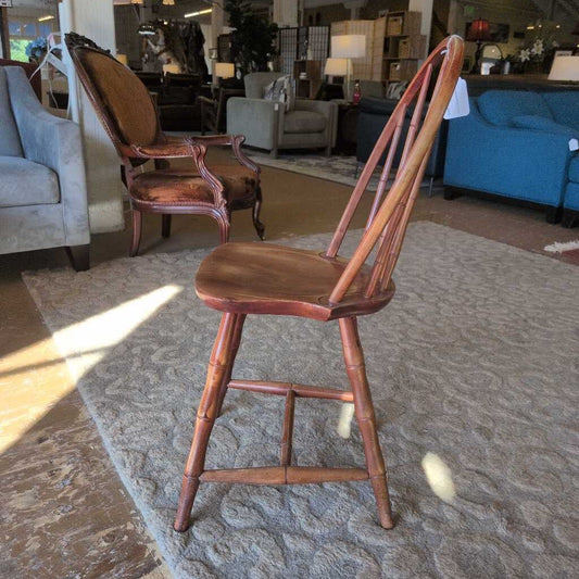 Wooden chair in a furniture store with other chairs and a blue couch in the background.