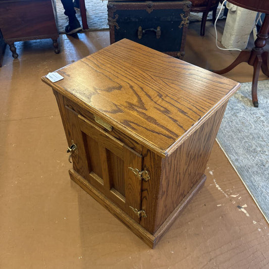 Wooden cabinet with a small door on a brown floor