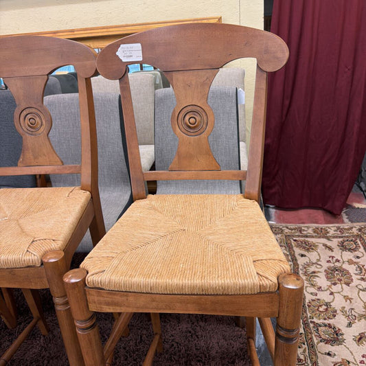 Wooden chairs with woven seats in a room setting