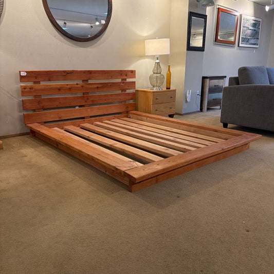 Wooden bed frame in a room with furniture and decor