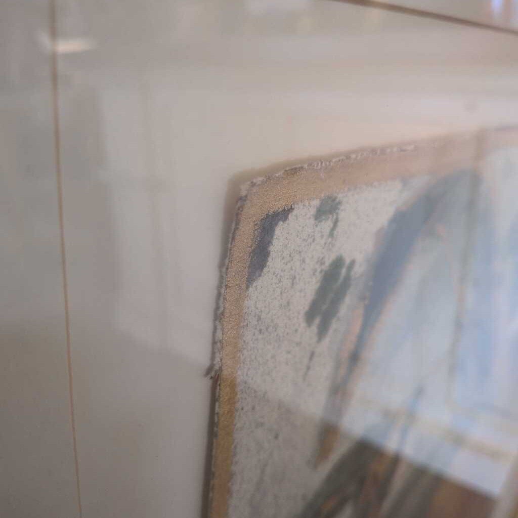 Close-up of a tiled wall with a corner area showing signs of wear and damage.