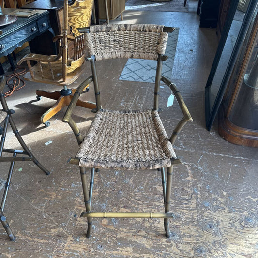 Wicker chair on a wooden floor with a desk and other furniture in the background
