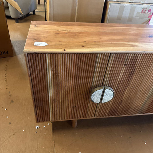 Wooden cabinet with slatted design and circular handle on a wooden floor.