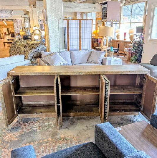 Wooden entertainment console with open doors in a living room setting