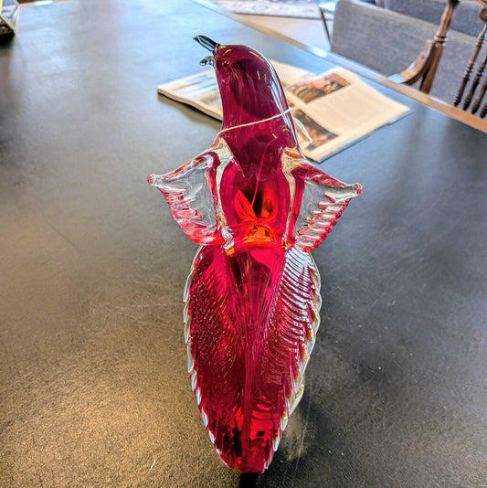Red glass fish ornament on a dark surface
