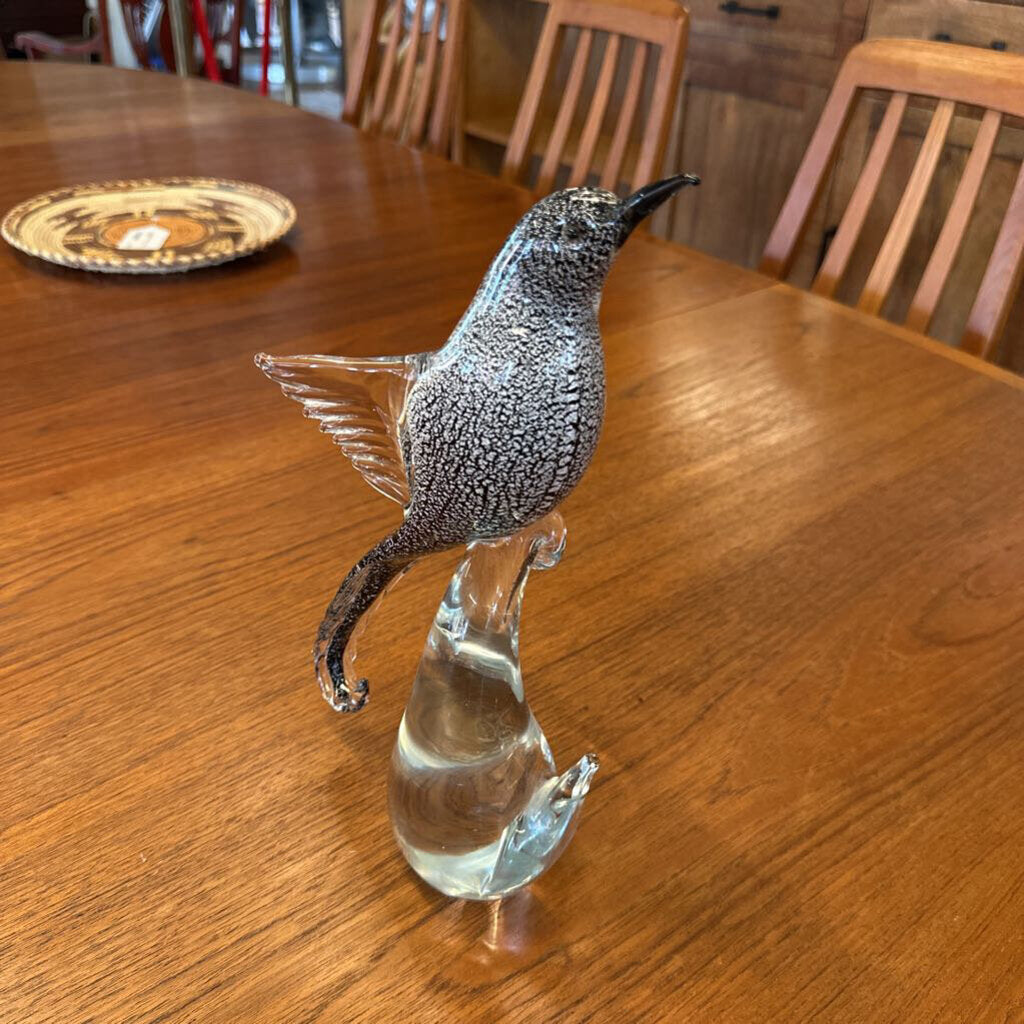 Glass bird sculpture on a wooden table
