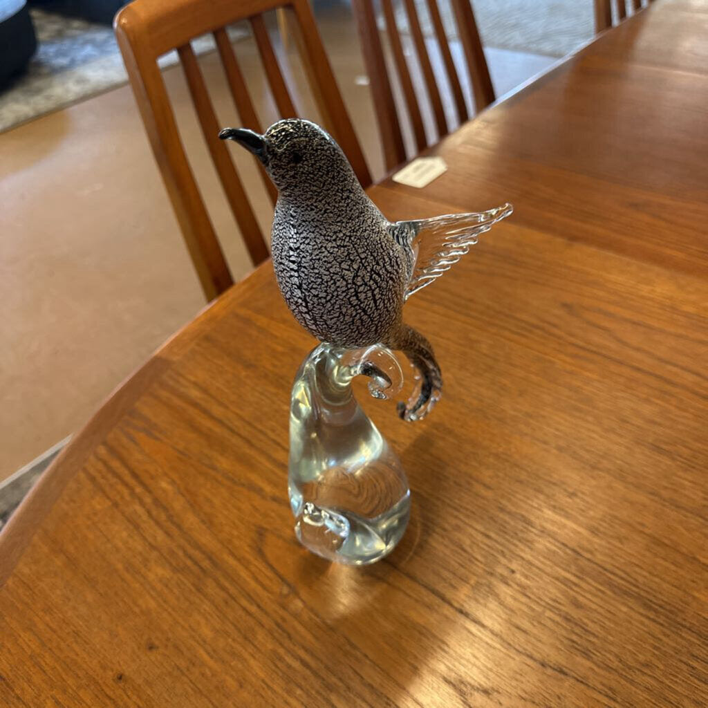 Glass bird figurine on a wooden table