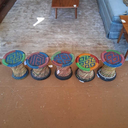 Colorful woven stools on a wooden floor with furniture in the background