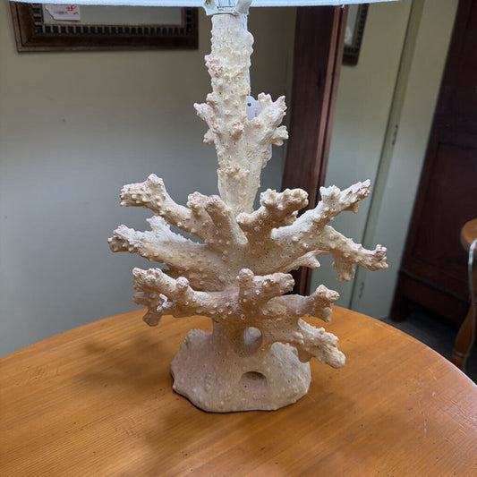 Coral-like sculpture on a wooden surface with a neutral background