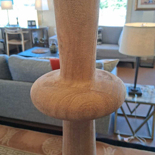Close-up of a beige cat tree in a living room setting with furniture and decor.