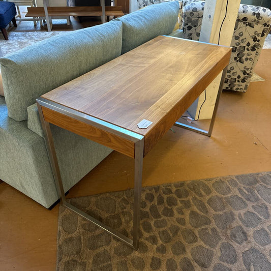 Wooden coffee table in a living room setting with a sofa and patterned rug.