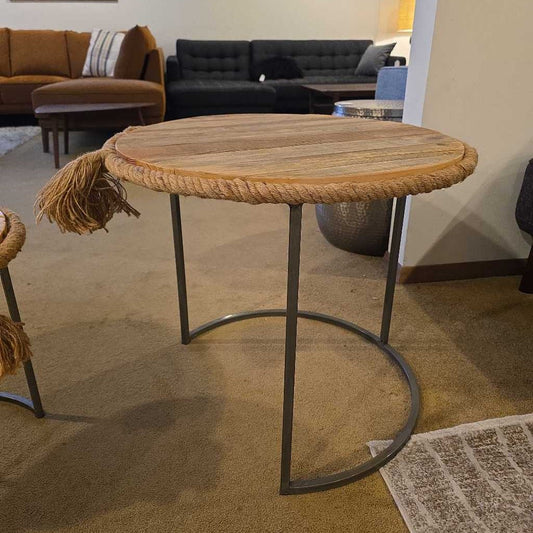 Round wooden table with metal legs in a living room setting