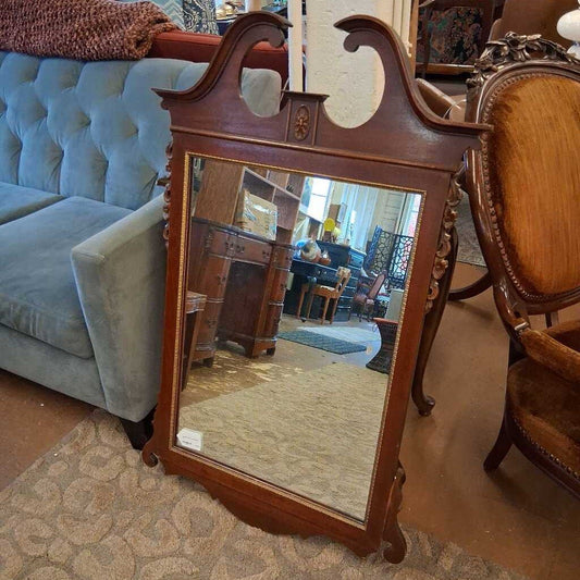 Wooden mirror with decorative frame in a room with furniture