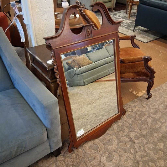 Wooden mirror with decorative frame in a room with furniture