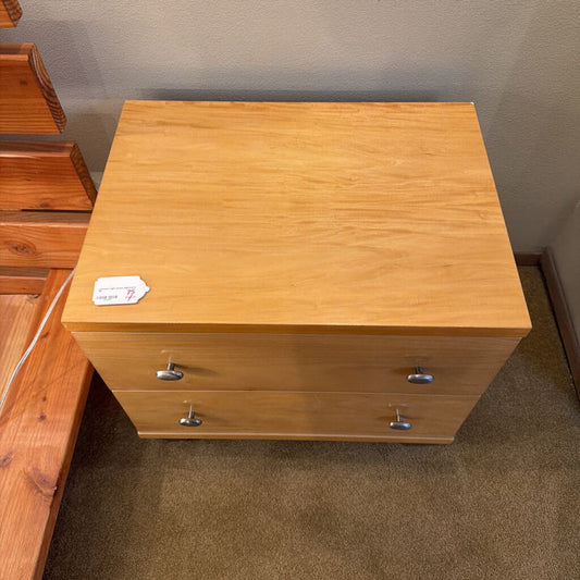 Wooden dresser with two drawers on a carpeted floor