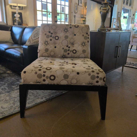 Patterned chair in a living room setting with a couch and decor items.