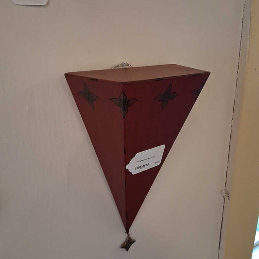 Triangular wooden shelf with decorative elements on a wall.