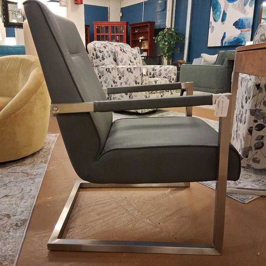 Modern gray armchair with metal frame in a showroom setting