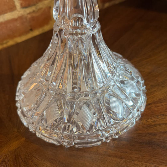 This exquisite lead crystal ship's decanter is a classic example of fine barware, designed with a characteristic broad, weighted base for stability. The vessel features a deeply cut diamond and vertical wedge pattern that wraps around the body, creating brilliant light refraction.