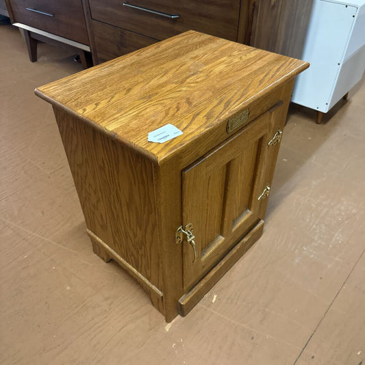 Wooden cabinet with a small door on a brown floor