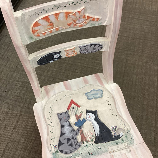 Chair with cat-themed cushion and backrest on a carpeted floor
