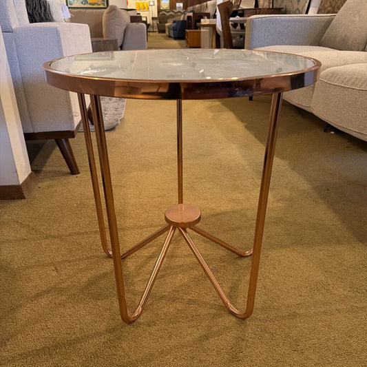 Small round table with a metallic finish in a furniture store setting