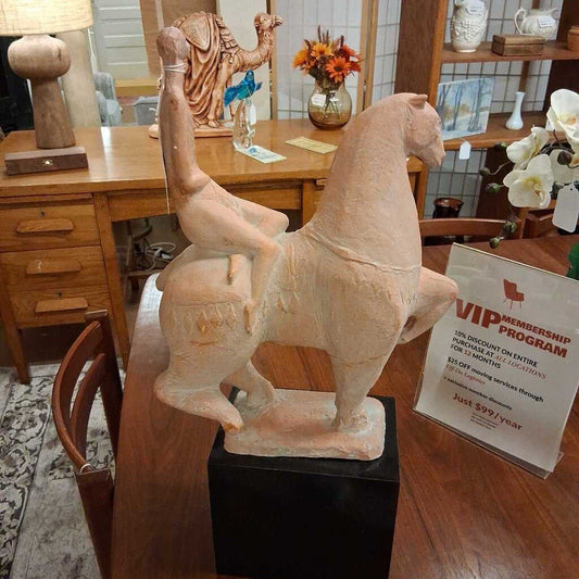 Decorative horse sculpture on a wooden table with a VIP membership program sign in the background.