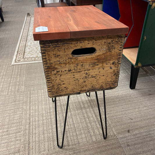 Wooden side table with metal legs on a carpeted floor
