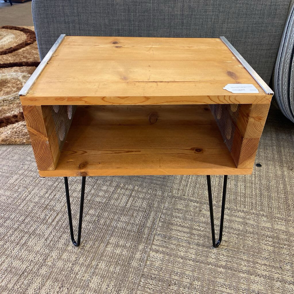 Wooden side table with metal legs on a carpeted floor