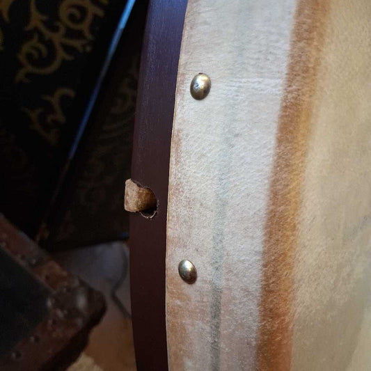 Close-up of a leather belt with a hole and metal buckle.