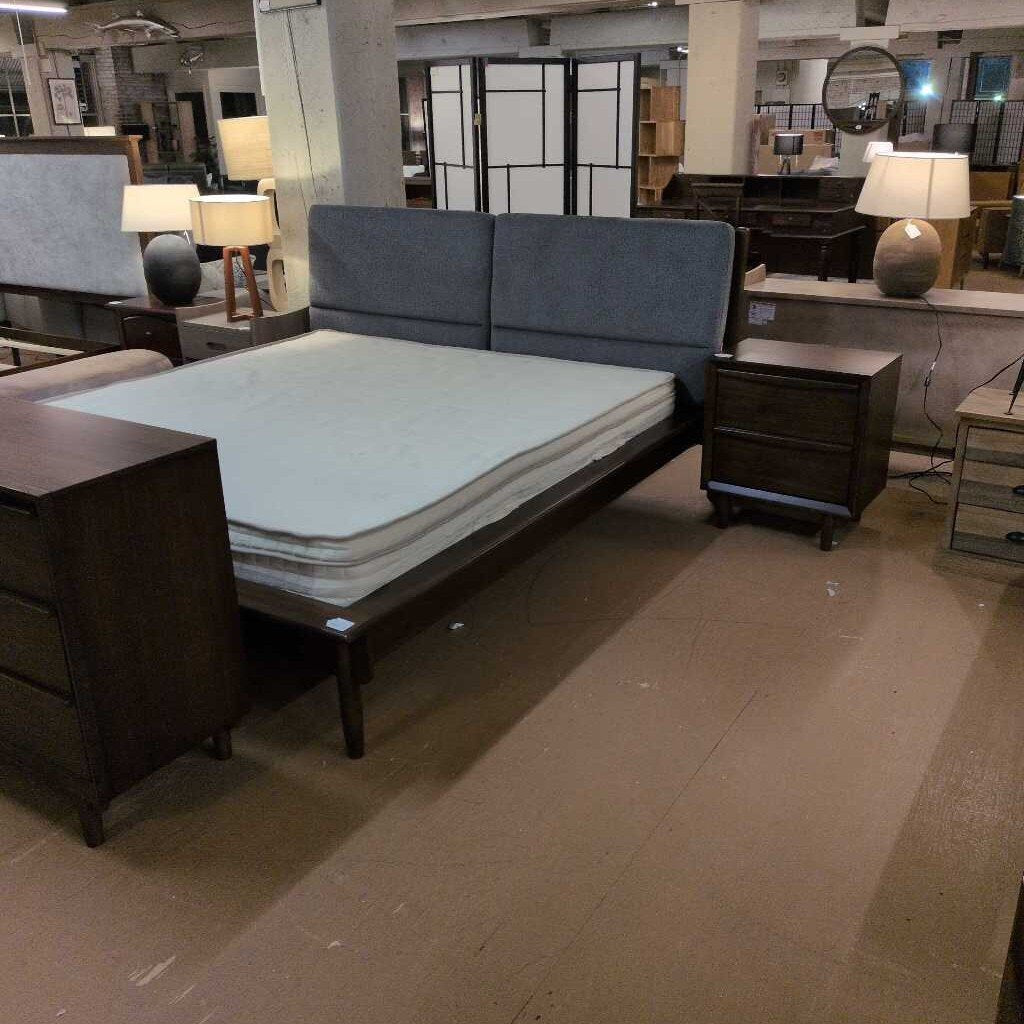 Bedroom furniture set with bed, nightstands, and lamps in a showroom.