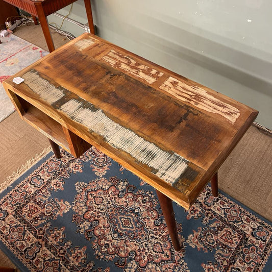 Wooden coffee table with a textured surface on a patterned rug