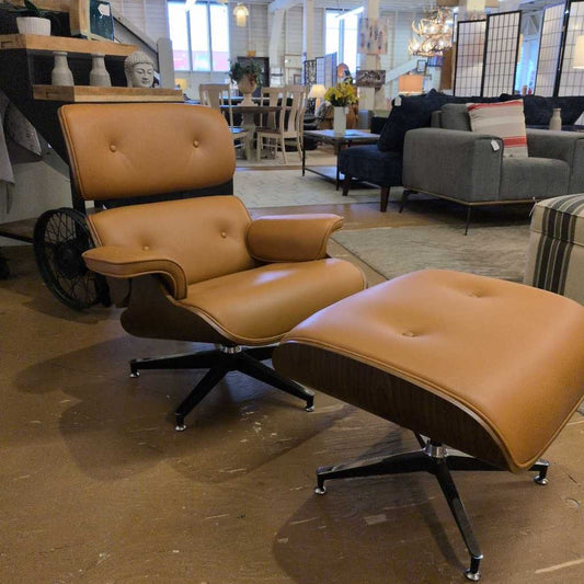Brown leather Eames-style chair and ottoman in a room with furniture and decor.