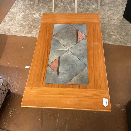 Wooden cabinet with glass panel featuring geometric design on a tiled floor.