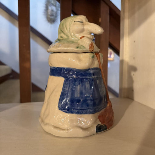 Vintage ceramic figure of a woman with a blue apron on a wooden surface