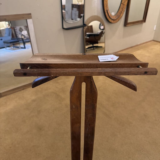 Wooden display stand with a card on a beige floor, possibly in an exhibition setting.