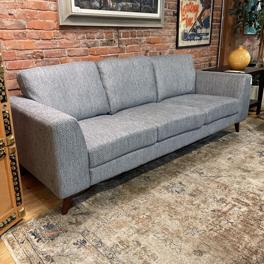 grey sofa with a brick wall behind