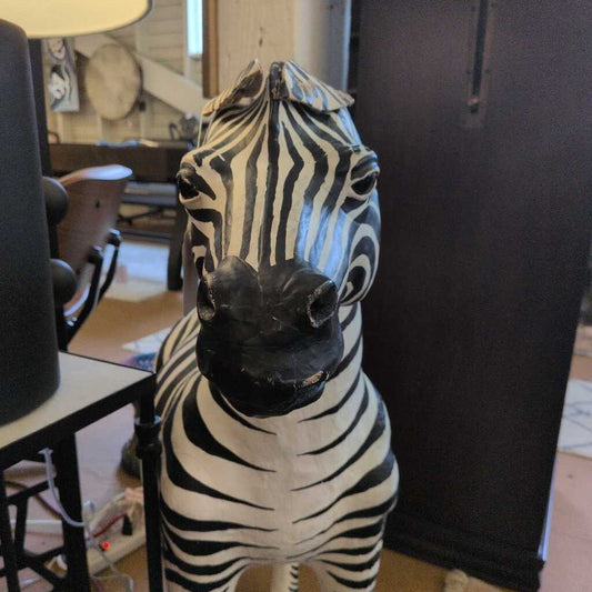 Zebra statue in a room with furniture and decor