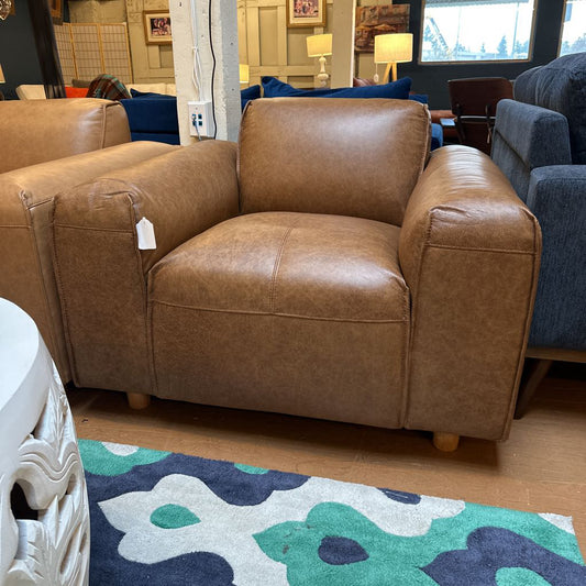 Brown leather armchair with a price tag in a showroom setting