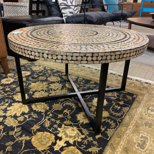 Round mosaic table with decorative pattern on a floral rug