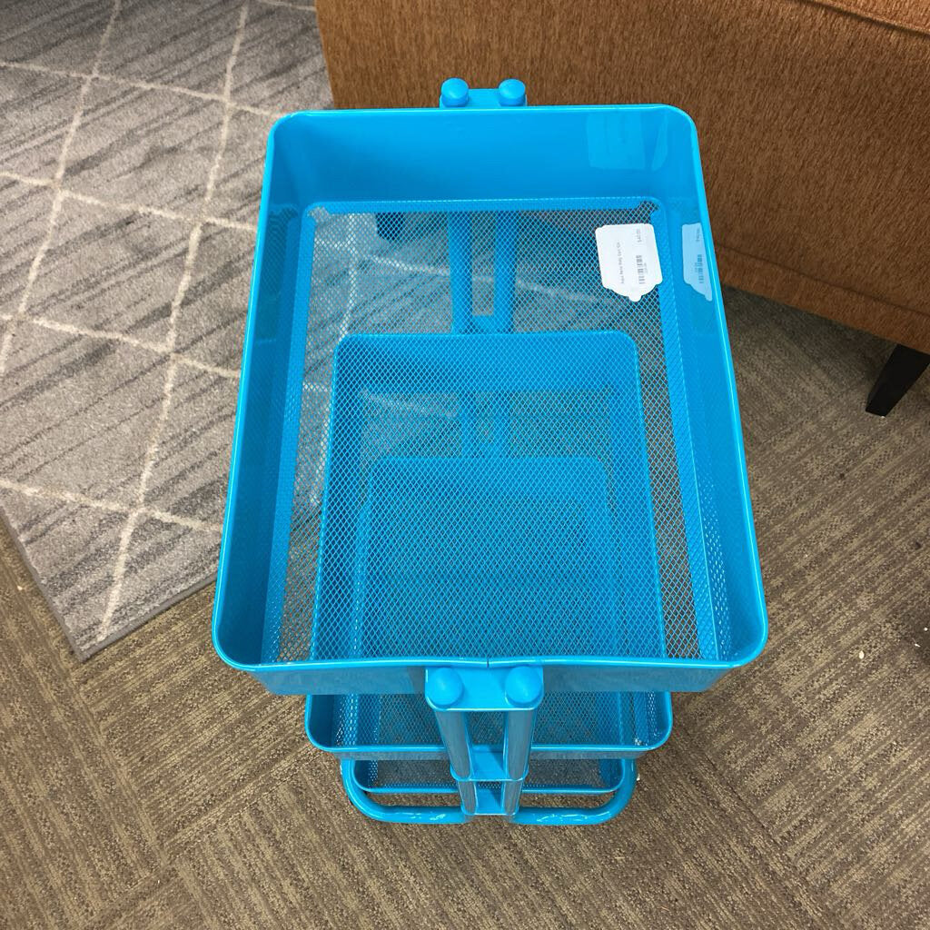 Blue mesh storage cart on a carpeted floor with a brown couch in the background