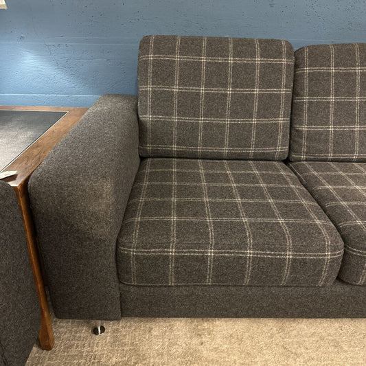 Gray checkered sofa against a blue wall.