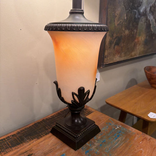 Decorative table lamp with a warm glow on a rustic wooden surface.