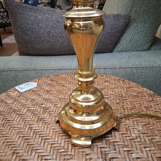 Gold lamp on a woven table with a blurred background