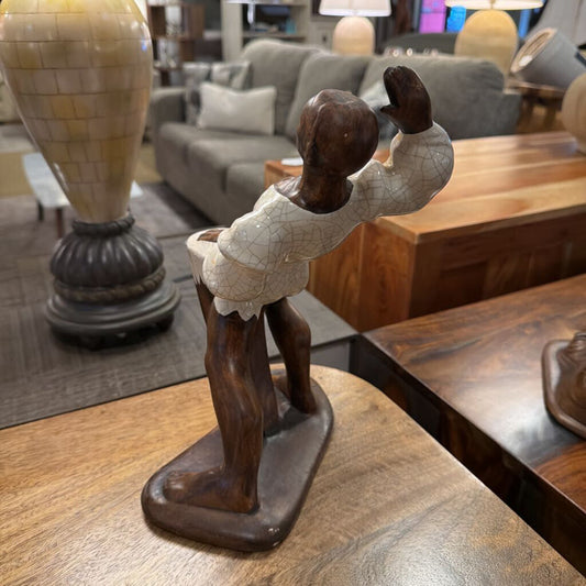 Wooden sculpture of a child on a table in a living room setting
